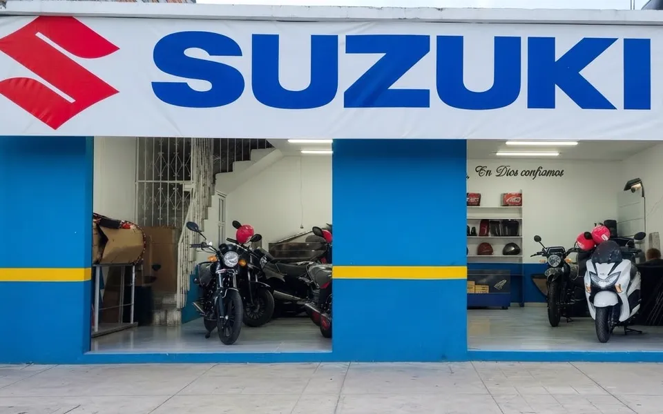 Fachada de la agencia Suzuki de OLAM, con motos nuevas en exhibición tras las vitrinas.